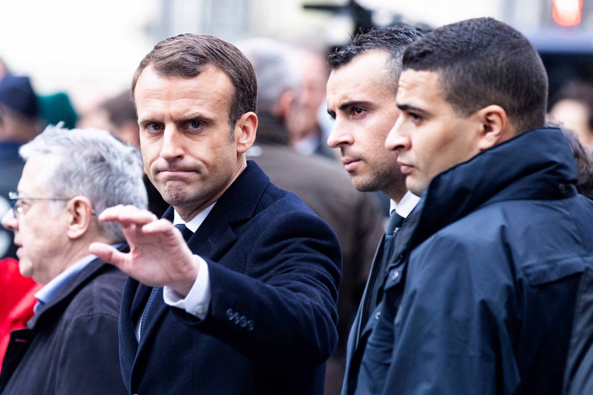 epa07205324 French President Emmanuel Macron (C) waves to citizens as he assesses the damages of the 'Yellow Vests' protest a day earlier, next to the Champs Elysee in Paris, France, 02 December 2018 (03 December 2018). The so-called 'gilets jaunes' (yellow vests) are a protest movement, which reportedly has no political affiliation, is protesting across the nation over high fuel prices.  EPA/ETIENNE LAURENT FRANCE PROTEST YELLOW VESTS AFTERMATH