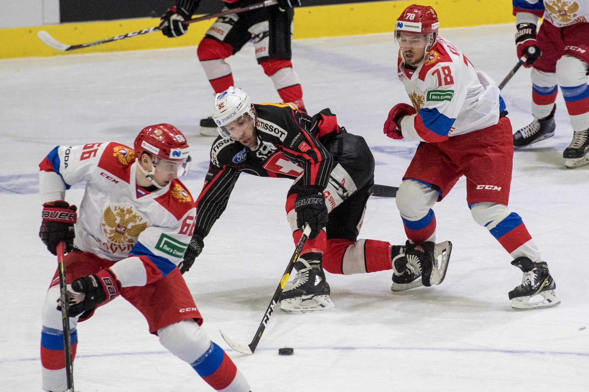 Switzerland's player Romain Loeffel, centre, and Russia's player Aleksei Kruchinin, right, during a international ice hockey game between Switzerland and Russia Olympic Team, at the Lucerne Cup in Lucerne, Switzerland, on Friday, December 14, 2018. (KEYSTONE/Urs Flueeler) SWITZERLAND HOCKEY LUCERNE CUP