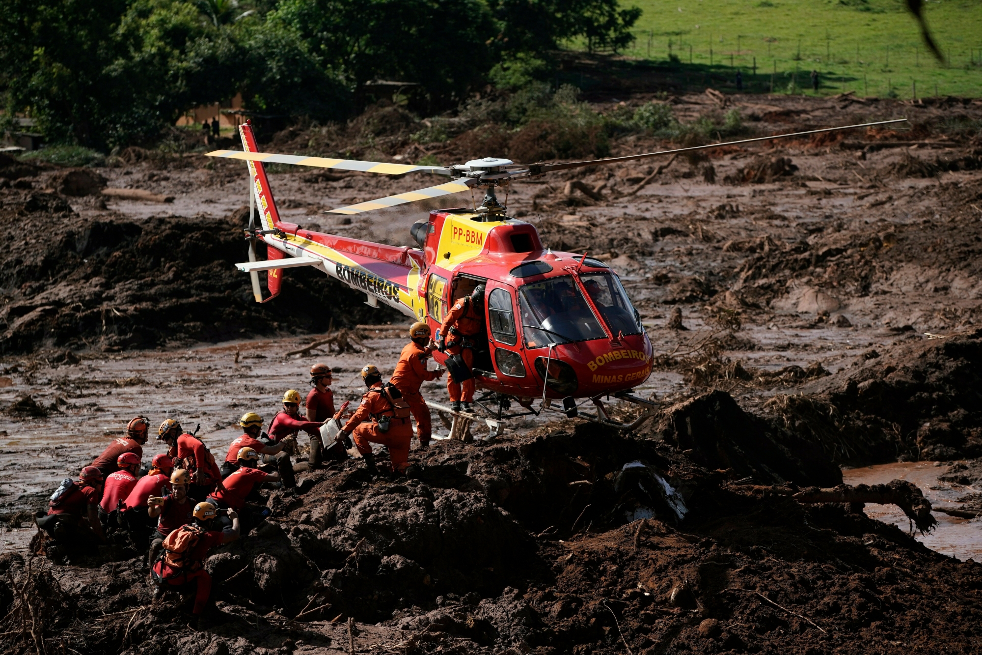 Firefighters are resupplied as they search for victims of a dam collapse in Brumadinho, Brazil, Monday, Jan. 28, 2019. Firefighters on Monday carefully moved over treacherous mud, sometimes walking, sometimes crawling, in search of survivors or bodies four days after a dam collapse that buried mine buildings and surrounding neighborhoods with iron ore waste. (AP Photo/Leo Correa) Brazil Dam Collapse