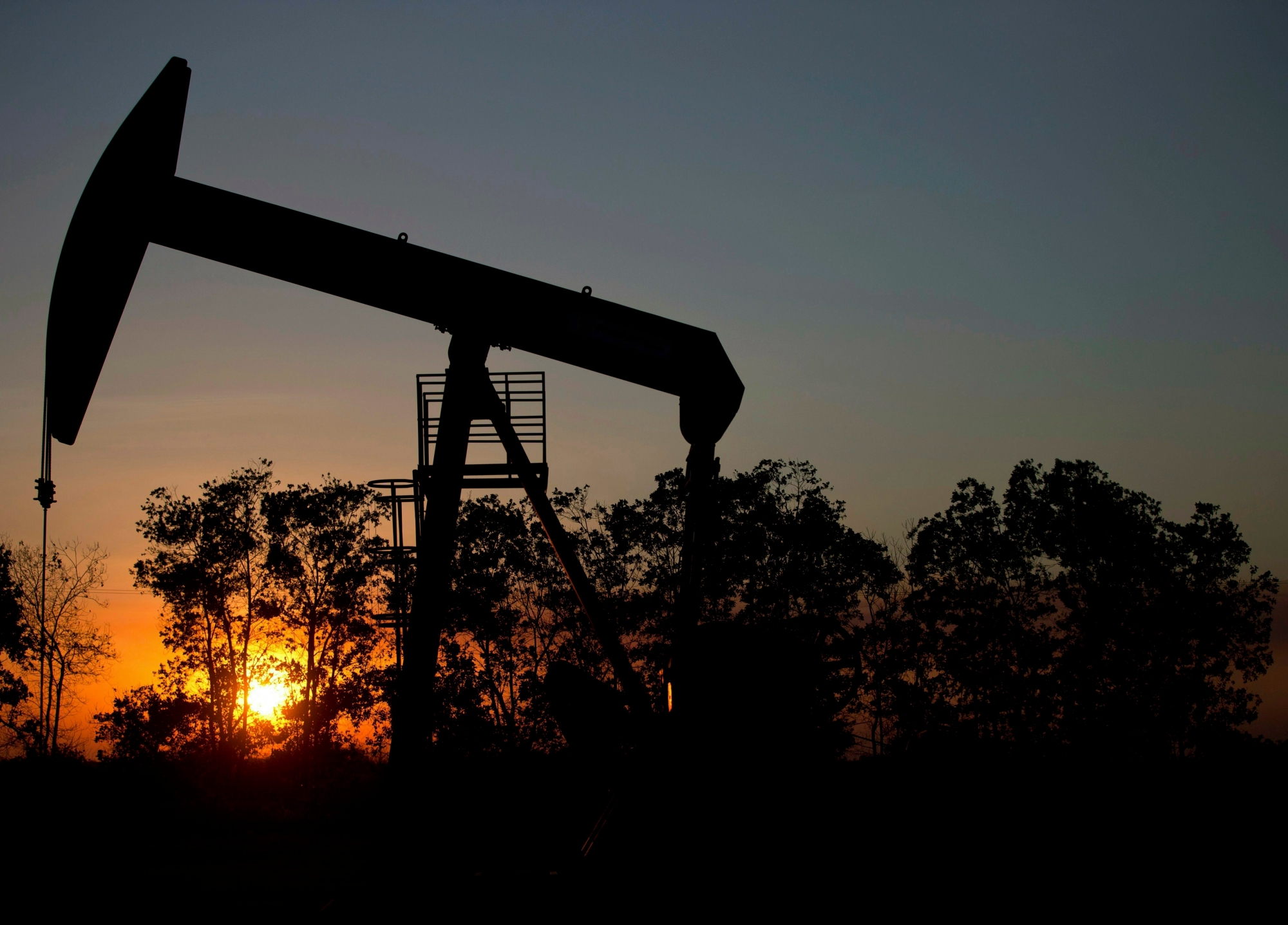 FILE - In this Feb. 19, 2015 file photo, the sun sets behind an oil well in a field near El Tigre, a town within Venezuela's Hugo Chavez oil belt, formally known as the Orinoco Belt. Venezuelan oil exports to the U.S. have declined steadily over the years, falling particularly sharply over the past decade as its production plummeted amid its long economic and political crisis. (AP Photo/Fernando Llano, File) AP Explains Venezuela Oil