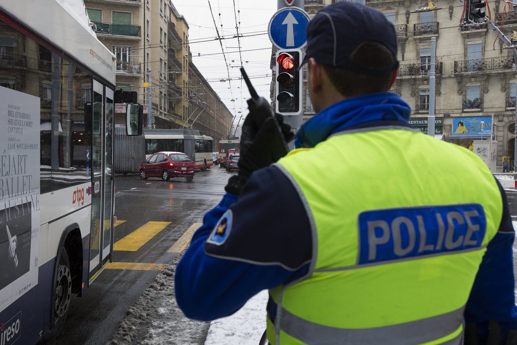 Un gendarme de la police genevoise annonce a ses collegues un automobiliste qui commet une infraction en tournant a gauche au bout du boulevard de Saint Georges, ce mardi 20 decembre 2011 a Geneve. La police genevoise intensifie ses controles de circulation aux endroits ou les transports publics sont penalises par "les comportements inadequats" de certains automobilistes. L'action est menee sur plusieurs semaines. (KEYSTONE/Salvatore Di Nolfi)