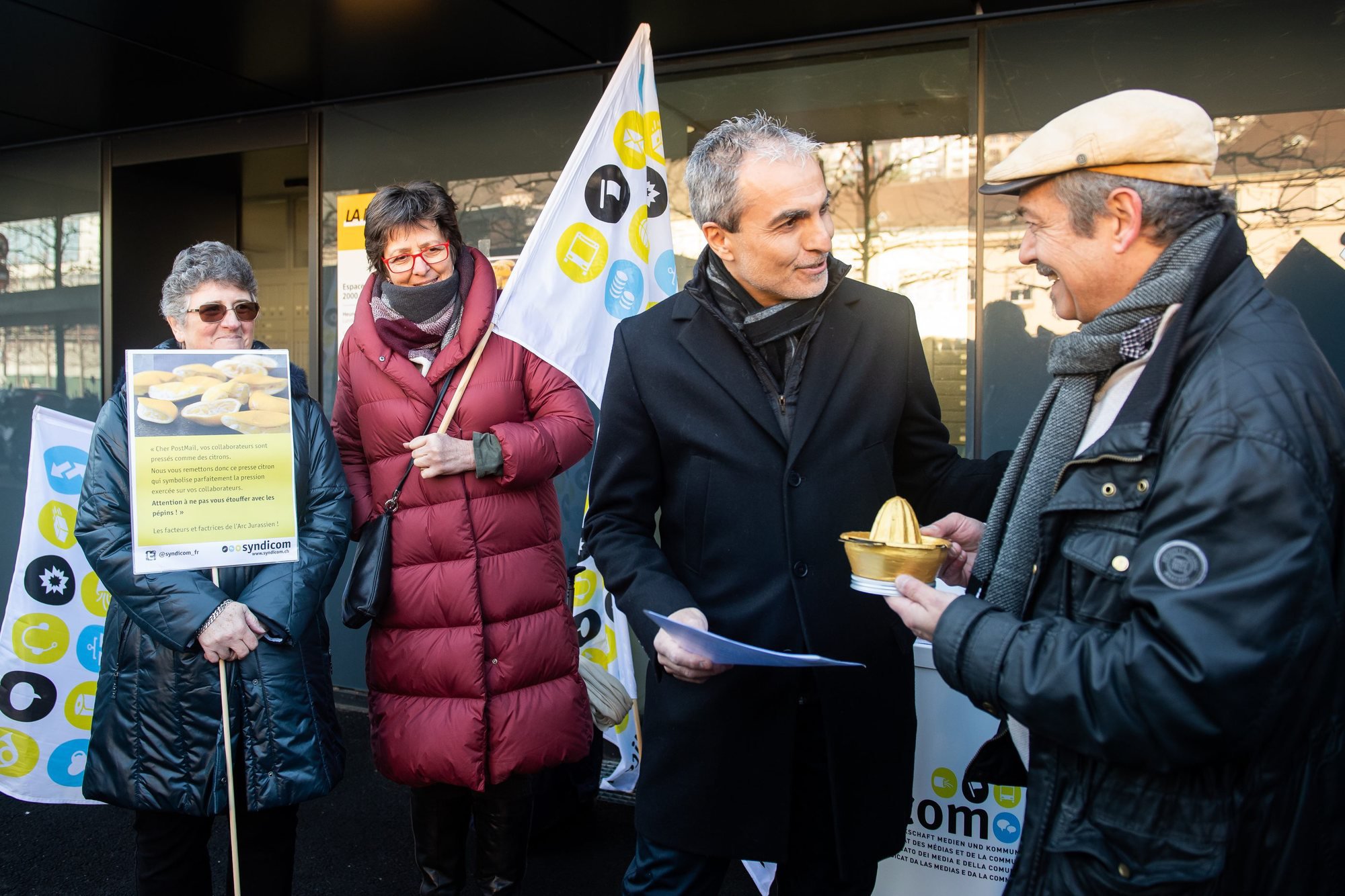 Le presse-citron a été remis ce jeudi matin devant la succursale de La Poste de la gare de Neuchâtel. Jean-François Laneve (à g.), responsable de la zone de distribution, l'a reçu des mains du syndicaliste Jean-François Donzé.
