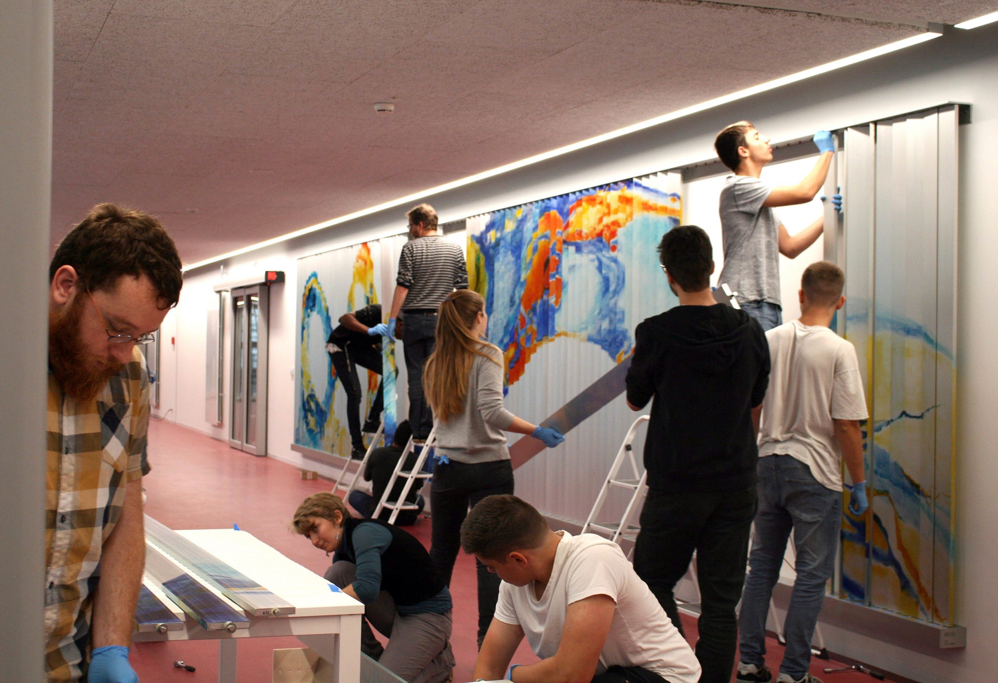 Les étudiants du CPLN en train de remonter la fresque mobile dans le hall de leur établissement.