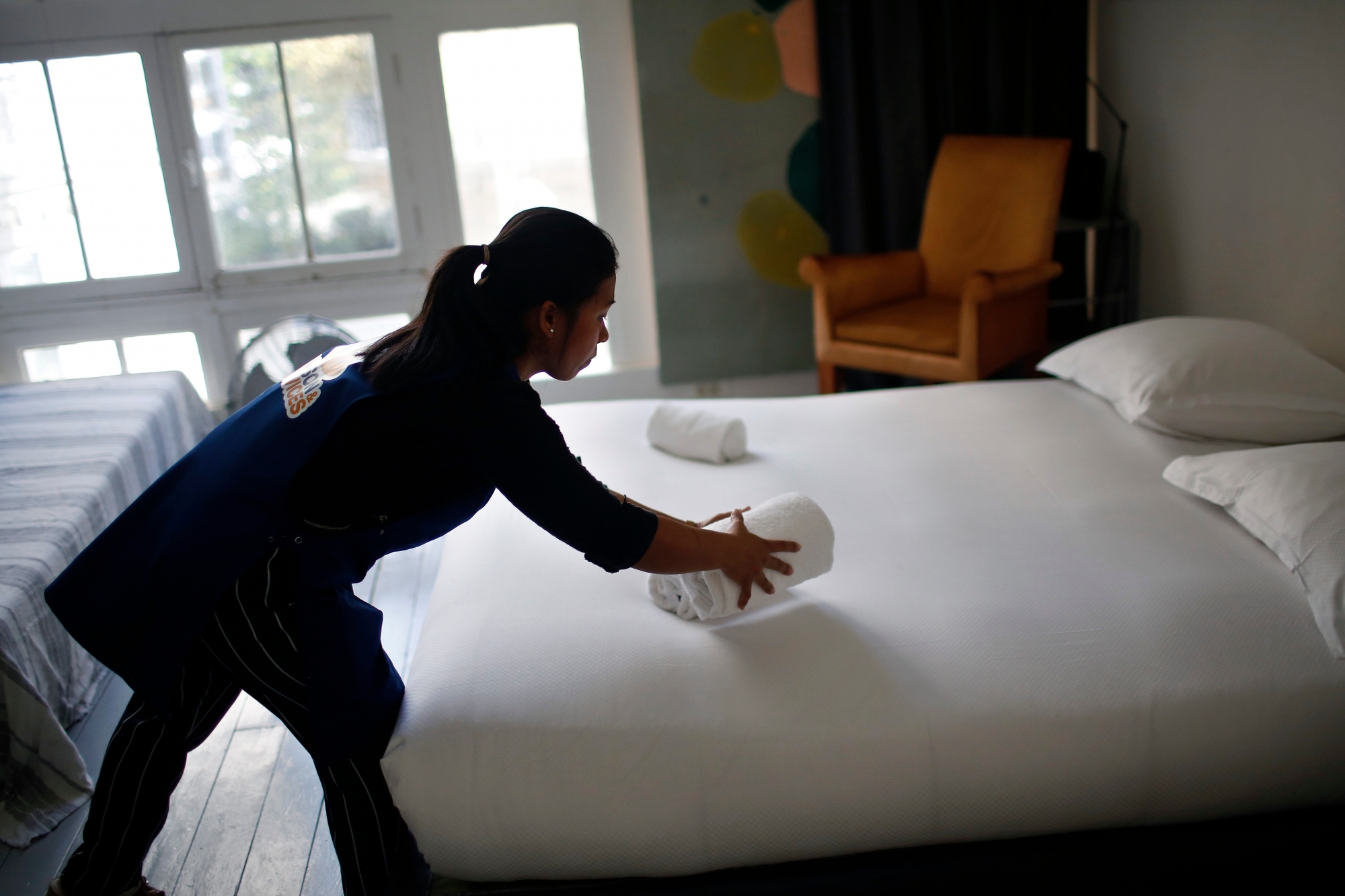 In this Thursday, Sept. 20, 2018 photo, a cleaning lady works in an apartment located on Airbnb in Paris. The spectacular growth of Airbnb in Paris, the top worldwide location for the internet giant is also raising alarms in the French capital. Some Parisians and officials at City Hall blame the site for driving Parisian families out of the city center, leading to school closures and concerns that the French capital is losing its life and charms.  (AP Photo/Thibault Camus) France Fighting Airbnb