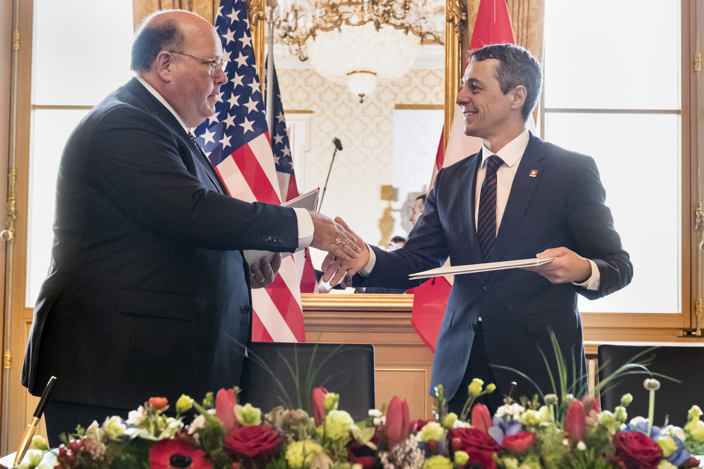 L'ambassadeur américain pour la Suisse et Ignazio Cassis se serrent la main après la signature de l'accord. 
