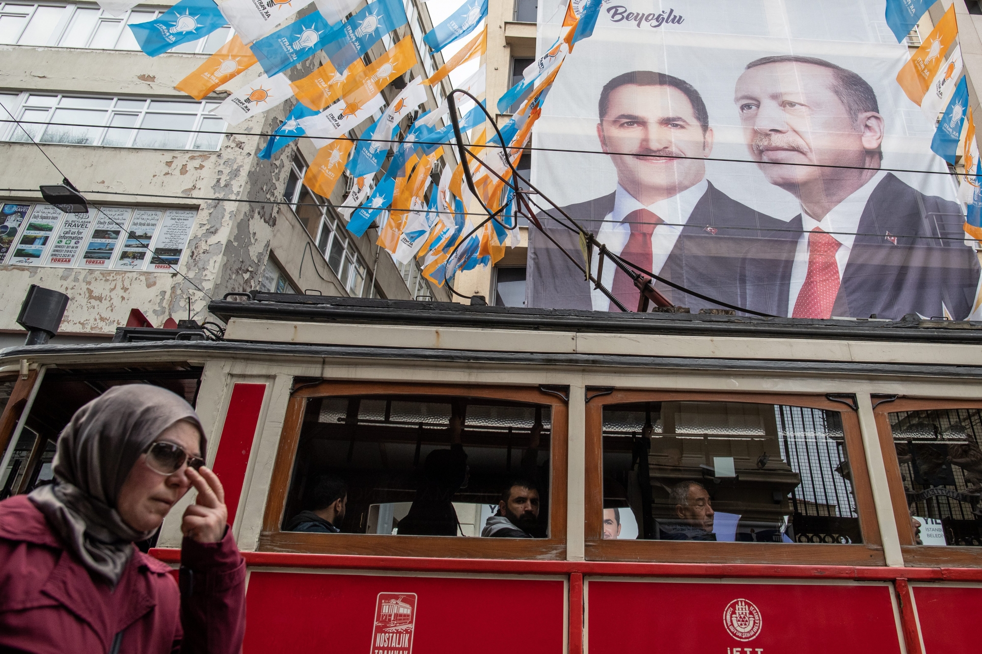 epa07480151 People pass in front of a huge banner with picture of Turkish President Recep Tayyip Erdogan in Istanbul, Turkey, 02 April 2019. According to preliminary results, CHP candidate for Istanbul mayor, Ekrem Imamoglu, beat the AKP candidate Binali Yildirim, by 25,000 votes in what was viewed as a blow to President Recep Tayyip Erdogan's grip on power, as the ruling party, an Islamist conservative outfit, also lost the capital, Ankara.  EPA/SEDAT SUNA TURKEY LOCAL ELECTIONS