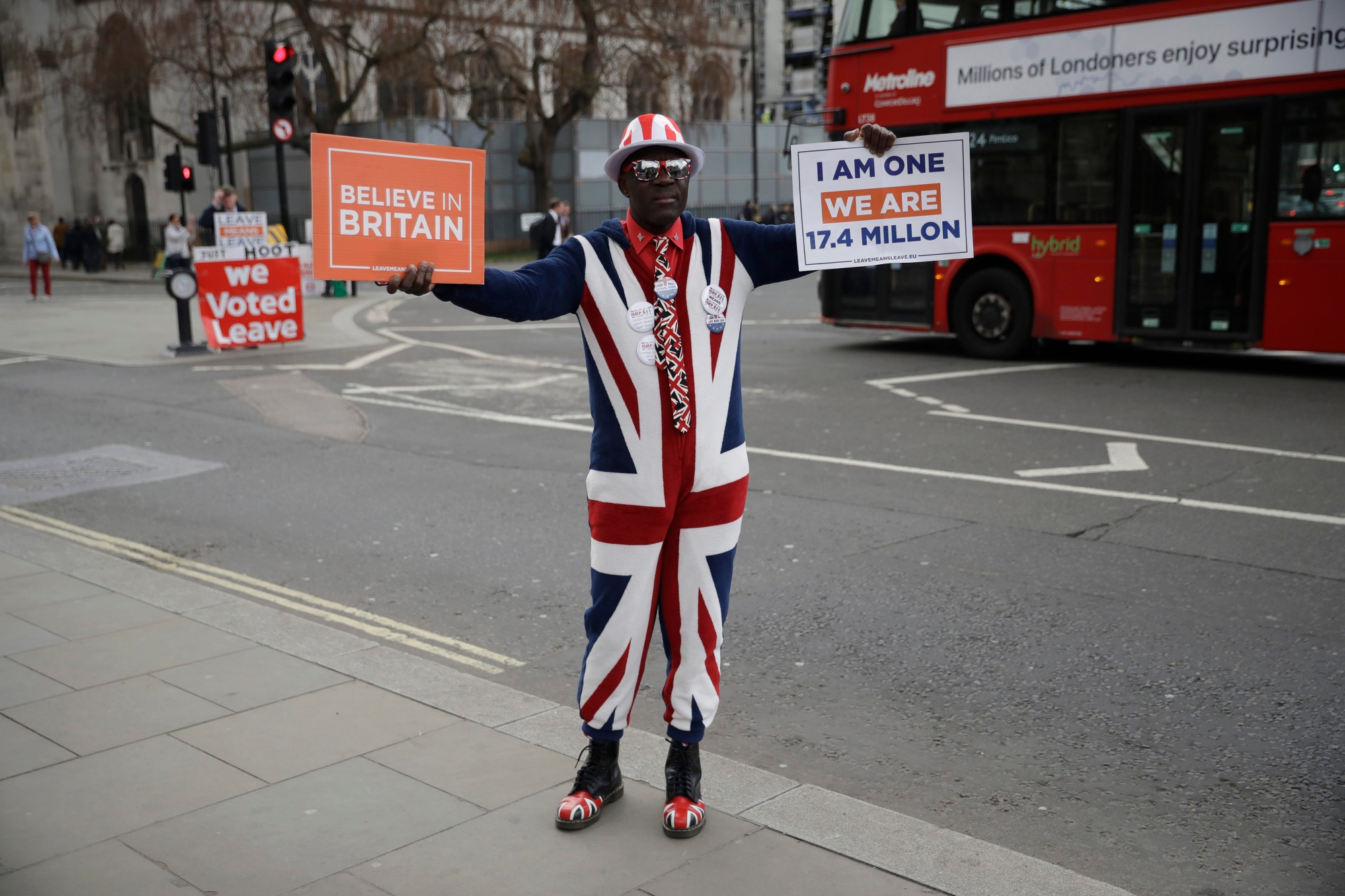 A pro-Brexit leave the European Union supporter holds up placards outside the Houses of Parliament in London, Wednesday, April 3, 2019. After failing repeatedly to win Parliament's backing for her Brexit blueprint, Britain's Prime Minister Theresa May dramatically changed gear Tuesday, saying she would seek to delay Brexit _ again _ and hold talks with the opposition to seek a compromise.  (AP Photo/Matt Dunham) Britain Brexit