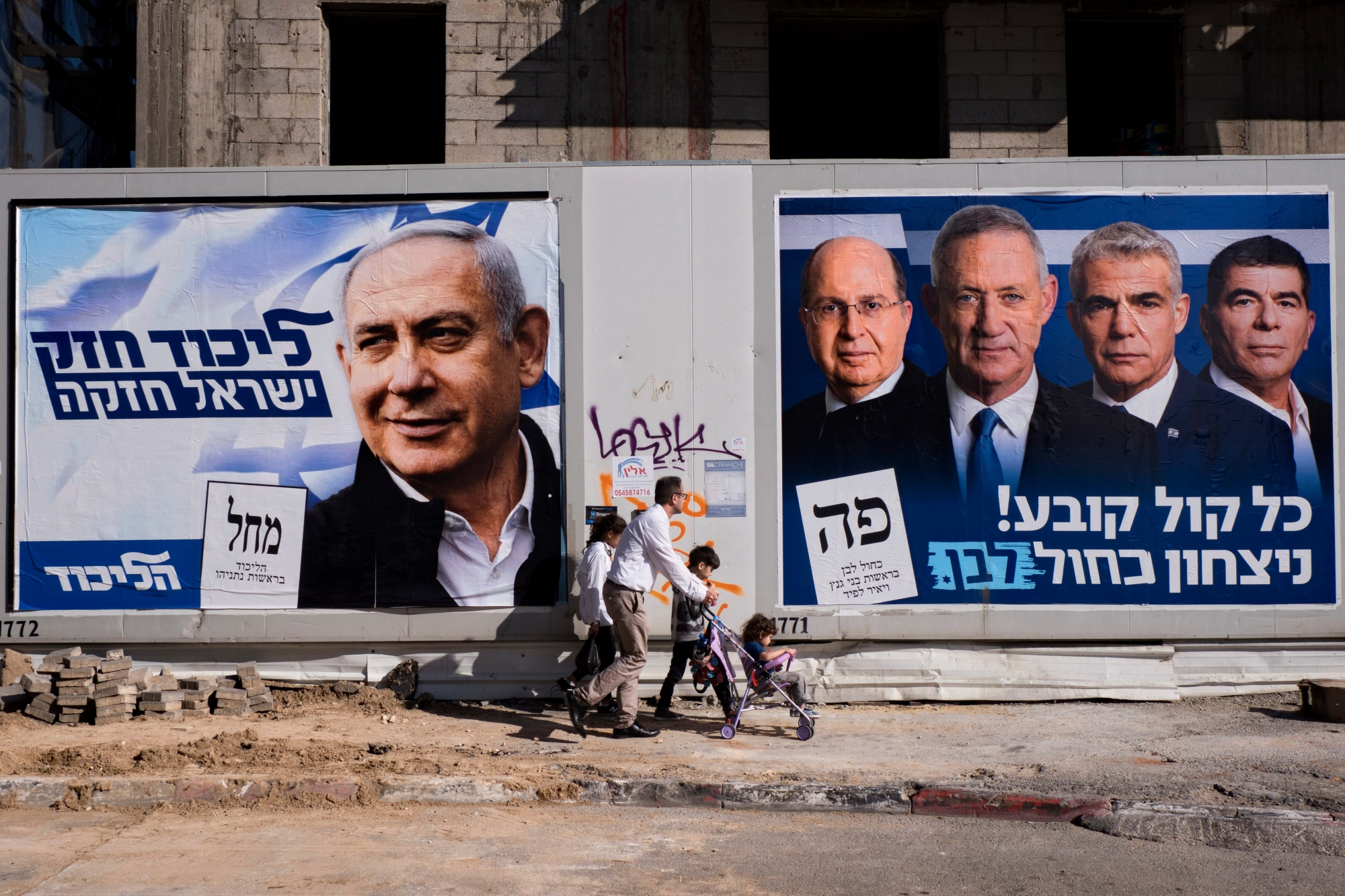 People walk by election campaign billboards showing Israeli Prime Minister and head of the Likud party Benjamin Netanyahu, left, alongside the Blue and White party leaders, from left to right, Moshe Yaalon, Benny Gantz, Yair Lapid and Gabi Ashkenazi, in Tel Aviv, Israel, Wednesday, April 3, 2019. Hebrew on billboards reads, left "Strong Likud strong Israel" on the right "Every vote matters, win Blue and White". (AP Photo/Oded Balilty) Israel Election