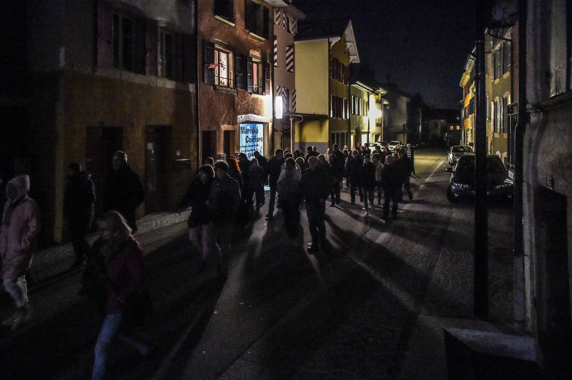 Dans la Grand'Rue de Corcelles, l'éclairage public était éteint samedi soir. Restaient les enseignes lumineuses des commerces et les fenêtres des logements.