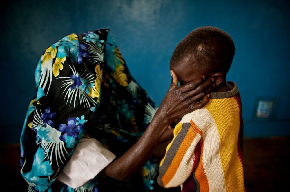 Au Congo, une femme victime d'un viol réconforte son enfant.