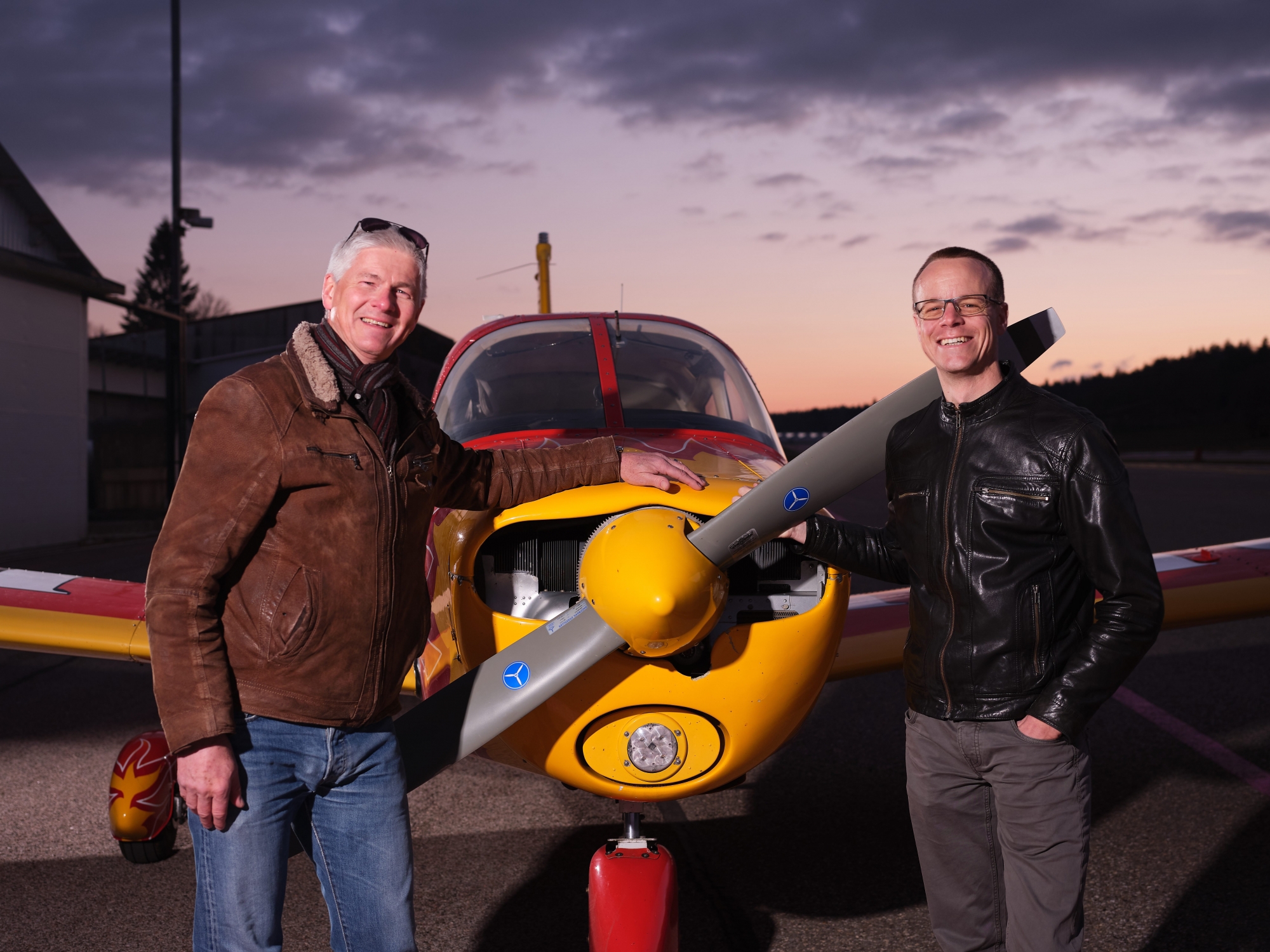 Jean-François Iseli (à gauche) et Yves Joly posent devant l'avion-école de l'Aéro-club des Montagnes neuchâteloises, le Piper Cherokee avec lequel ils ont volé en 2016 jusqu'à Dakar.
