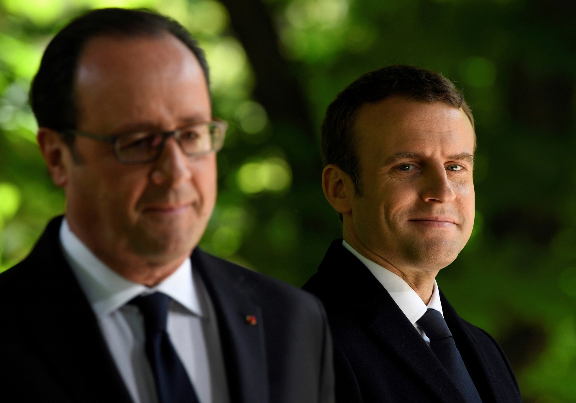 epa05954476 French President Francois Hollande (L) and newly elected president Emmanuel Macron (R) stand at the Jardins du Luxembourg in Paris, France, 10 May 2017 during a ceremony to mark the anniversary of the abolition of slavery and to pay tribute to the victims of the slave trade.  EPA/ERIC FEFERBERG / POOL FRANCE POLITICS SLAVERY