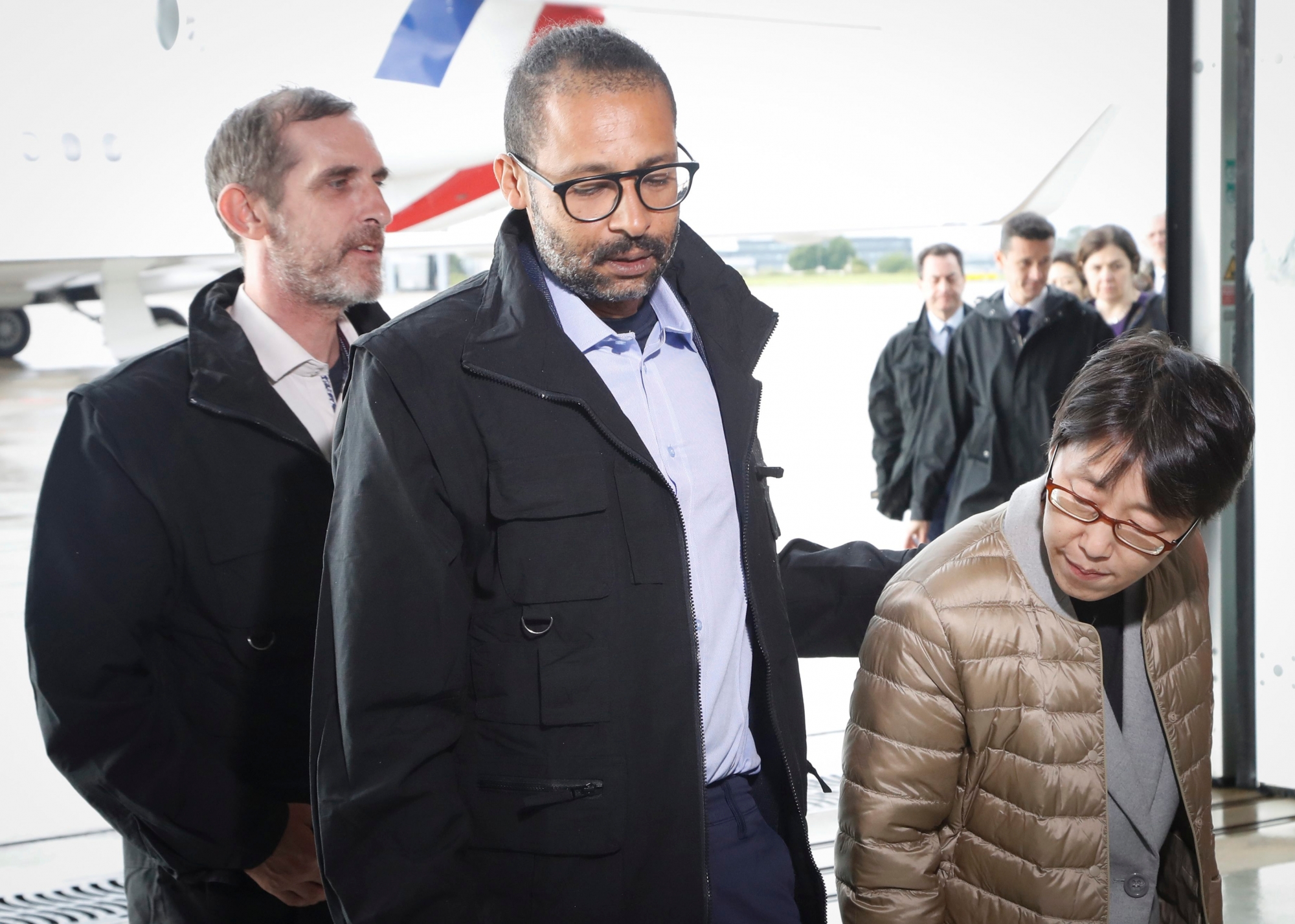 epa07562877 Freed French hostages Patrick Picque (L) and Laurent Lassimouillas (C) walk alongside a South Korean hostage (R) who has not been identified yet, upon their arrival at the Villacoublay airport, near Paris, France, 11 May 2019. According to the French presidency, the French army has released four hostages during an intervention in northern Burkina Faso. Two are French, one American and one South Korean citizen. Two French soldiers are reported to have been killed in the operation to free the hostages. The two French citizens were kidnapped on 01 May 2018 in Benin.  EPA/FRANCOIS GUILLOT / POOL  MAXPPP OUT FRANCE BURKINA FASO HOSTAGES