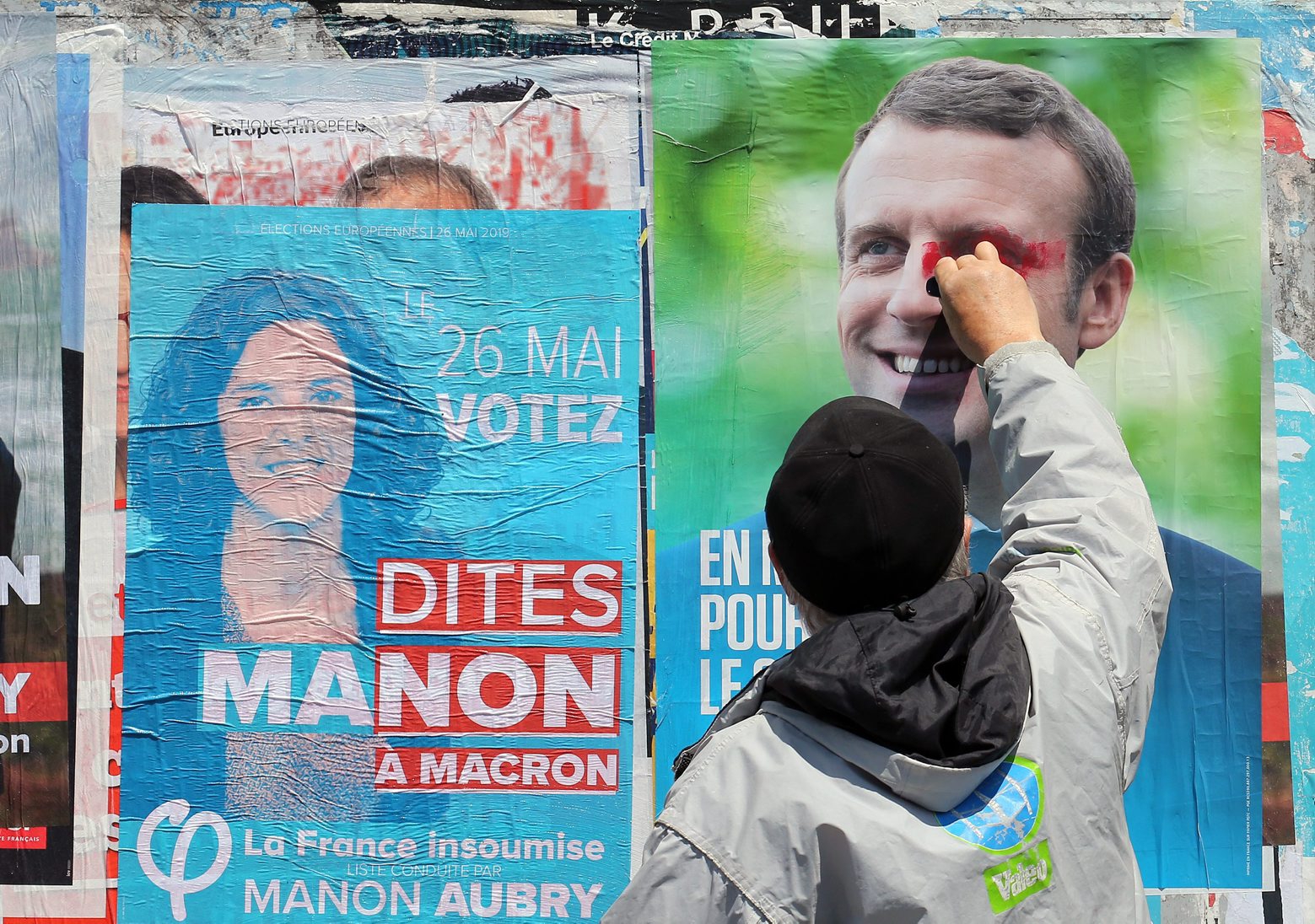 FILE - In this Tuesday, May 21, 2019 file photo, a supporter of French candidate for La France Insoumise party Marion Aubry, scribbles on a campaign poster of French president Emmanuel Macron in Saint-Jean-de-Luz, southwestern France. The European Parliament elections have never been so hotly anticipated or contested, with many predicting that this yearÄôs ballot will mark a coming-of-age moment for the euroskeptic far-right movement. The elections start Thursday May 23, 2019 and run through Sunday May 26 and are taking place in all of the European UnionÄôs 28 nations. (AP Photo/Bob Edme, File) European Elections What's At Stake