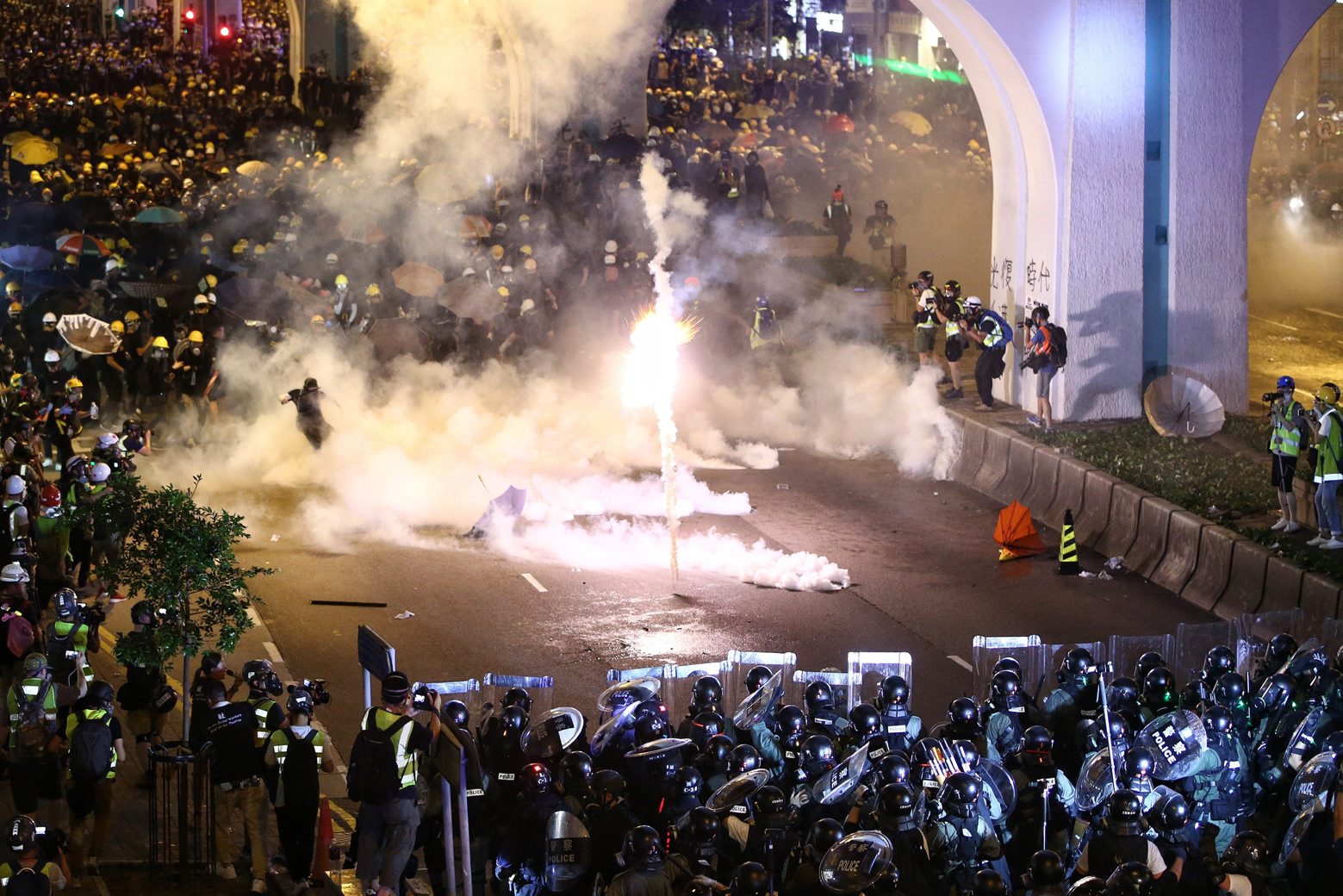 Protesters are engulfed by teargas during a confrontation with riot police in Hong Kong Sunday, July 21, 2019. Hong Kong police launched tear gas at protesters Sunday after a massive pro-democracy march continued late into the evening. The action was the latest confrontation between police and demonstrators who have taken to the streets to protest an extradition bill and call for electoral reforms in the Chinese territory. (Lo Kwanho/HK01 via AP) Hong Kong Protests