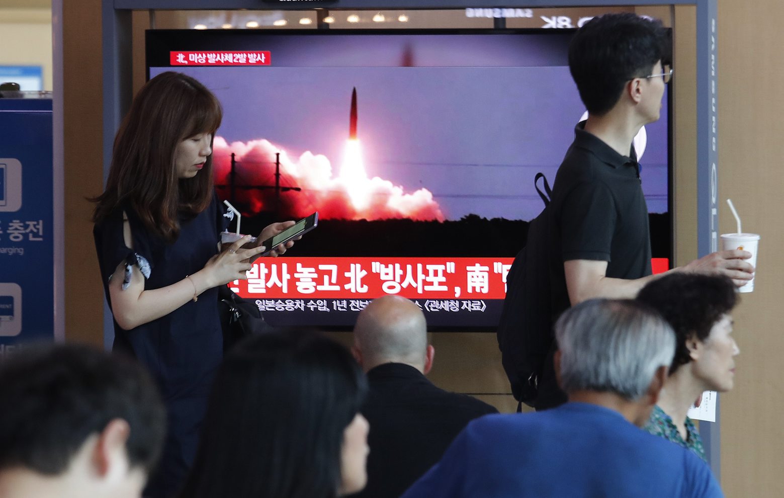 People watch a TV showing a file image of North Korea's missile launch during a news program at the Seoul Railway Station in Seoul, South Korea, Tuesday, Aug. 6, 2019. North Korea on Tuesday continued to ramp up its weapons demonstrations by firing unidentified projectiles twice into the sea while lashing out at the United States and South Korea for continuing their joint military exercises that the North says could derail fragile nuclear diplomacy. The sign reads "North Korea's multiple rocket launchers system." (AP Photo/Ahn Young-joon) South Korea North Korea Projectiles