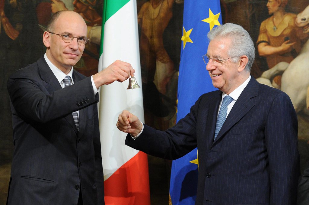 epa03679915 Italy's new Prime Minister Enrico Letta (L) receives a bell by outgoing Prime Minister Mario Monti to mark the government handover after the swearing-in ceremony of the new government at Quirinal palace in Rome, Italy, 28 April 2013. Italy's new grand coalition government was sworn in on 28 April, ahead of parliamentary votes of confidence next week that will formally bring to an end weeks of political stalemate in the eurozone's third-largest economy.  EPA/ETTORE FERRARI