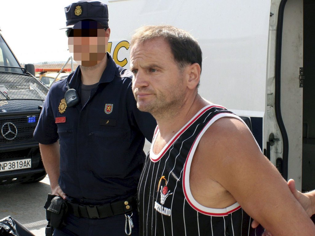 epa02301880 A photo released by the Spanish National Police shows Veselin Vlahovic, also known as 'Batko', or 'Grbavica monster' (R), as he is handed over by Spanish National Police officers (appointed to Police International Cooperation Unit) to Bosnia Herzegovina authorities in Madrid, central Spain, on 26 August 2010. Veselin Vlahovic, a former Serb soldier wanted on charges of genocide, rape and torture during the Balkan war in the early 1990s, had three pending international arrest warrants and was arrested in Alicante, Spain, in March 2010 on different charges such as robbery and burglary during an operation to capture a group of eastern Europe burglars.  EPA/SPANISH NATIONAL POLICE/HANDOUT  EDITORIAL USE ONLY/NO SALES