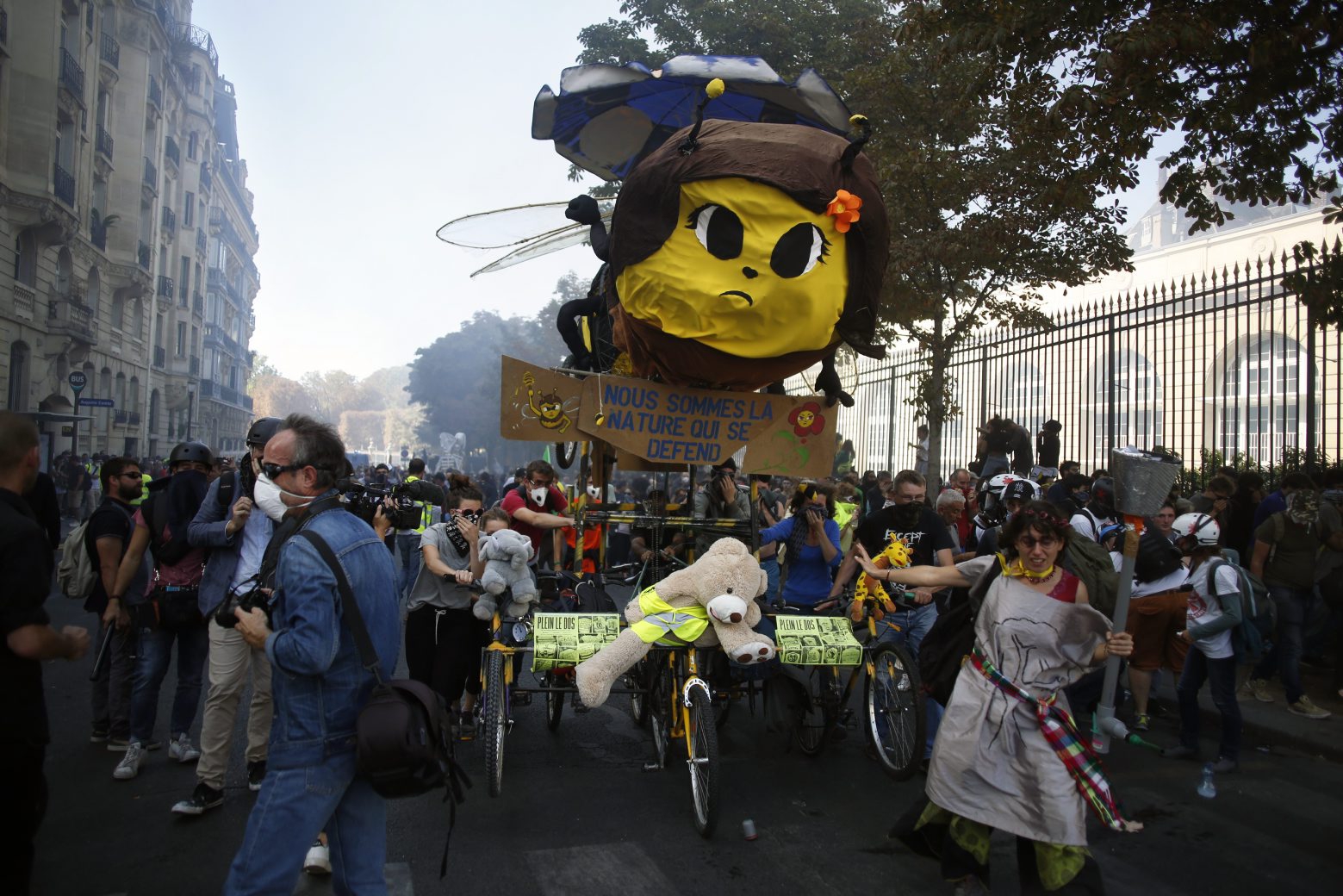 Protestors push a float with a giant bee on it during a climate demonstration, in Paris, Saturday, Sept. 21, 2019. Scuffles broke out in Paris between some violent activists and police which responded with tear gas at a march for climate gathering thousands of people in Paris. (AP Photo/Thibault Camus) France Climate Protests