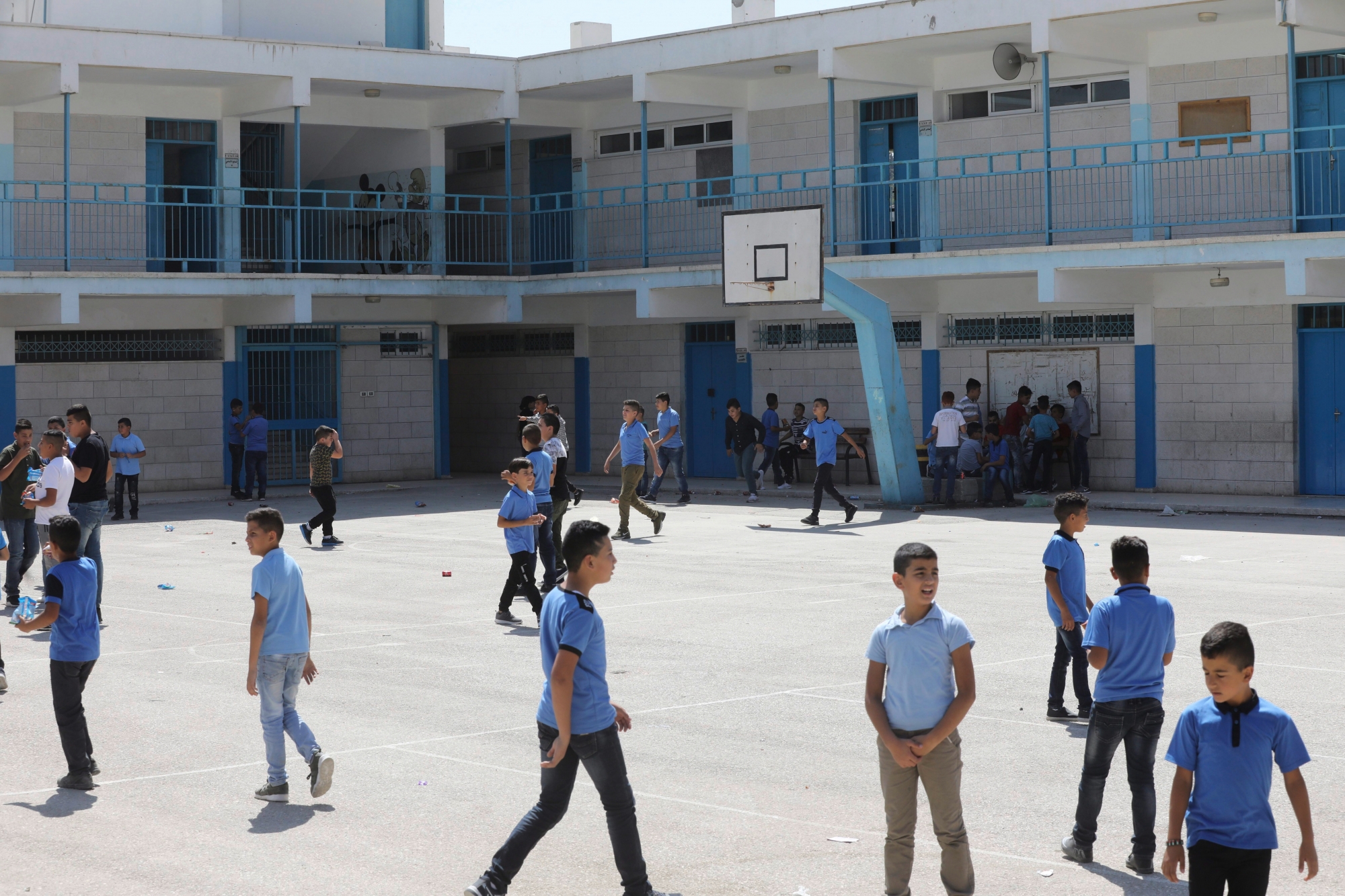 epa06980442 Palestinian children arrive to their UNRWA school during the first school day at al-Jalazoun refugee camp near the west bank city of Ramallah, 29 August 2018. According to media reports on 25 August 2018, the United States cut over 200 million US dollar in aid to Palestinians in the West Bank and Gaza Strip. US President Donald Trump reportedly ordered the State Department to direct the funds to 'high priority projects elsewhere'. The move comes after the US State Department suspended 65 million US dollar in aid to the United Nations Relief and Works Agency for Palestine Refugees in the Near East (UNRWA).  EPA/ALAA BADARNEH MIDEAST ISRAEL PALESTINIANS REFUGEES USA AID CUTS