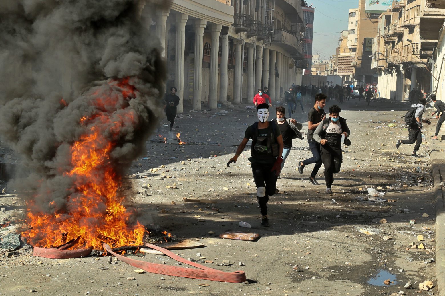 Riot police try to disperse anti-government protesters during clashes in Baghdad, Iraq, Friday, Nov. 22, 2019. Iraq's massive anti-government protest movement erupted Oct. 1 and quickly escalated into calls to sweep aside Iraq's sectarian system. Protesters occupy several Baghdad squares and parts of three bridges in a standoff with security forces. (AP Photo/Hadi Mizban) Iraq Protests