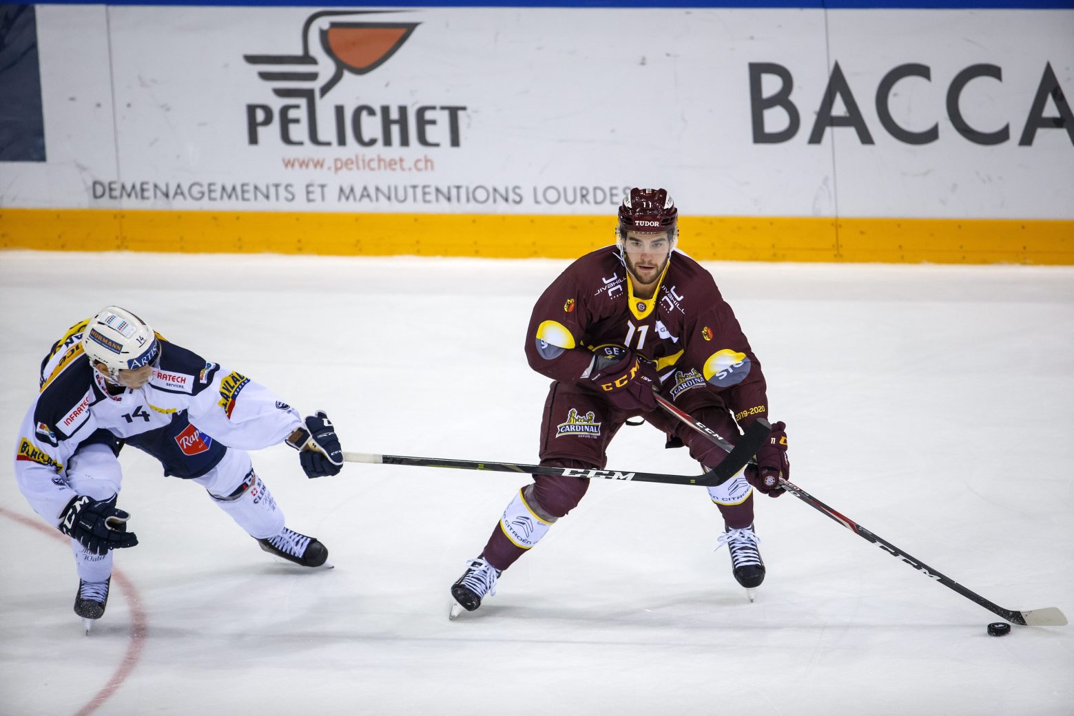 Ambri-Piotta's center Giacomo Dal Pian, left, vies for the puck with Geneve-Servette's forward Guillaume Maillard, right, during a National League regular season game of the Swiss Championship between Geneve-Servette HC and HC Ambri-Piotta, at the ice stadium Les Vernets, in Geneva, Switzerland, Friday, October 25, 2019. (KEYSTONE/Salvatore Di Nolfi) SWITZERLAND ICE HOCKEY SERVETTE AMBRI