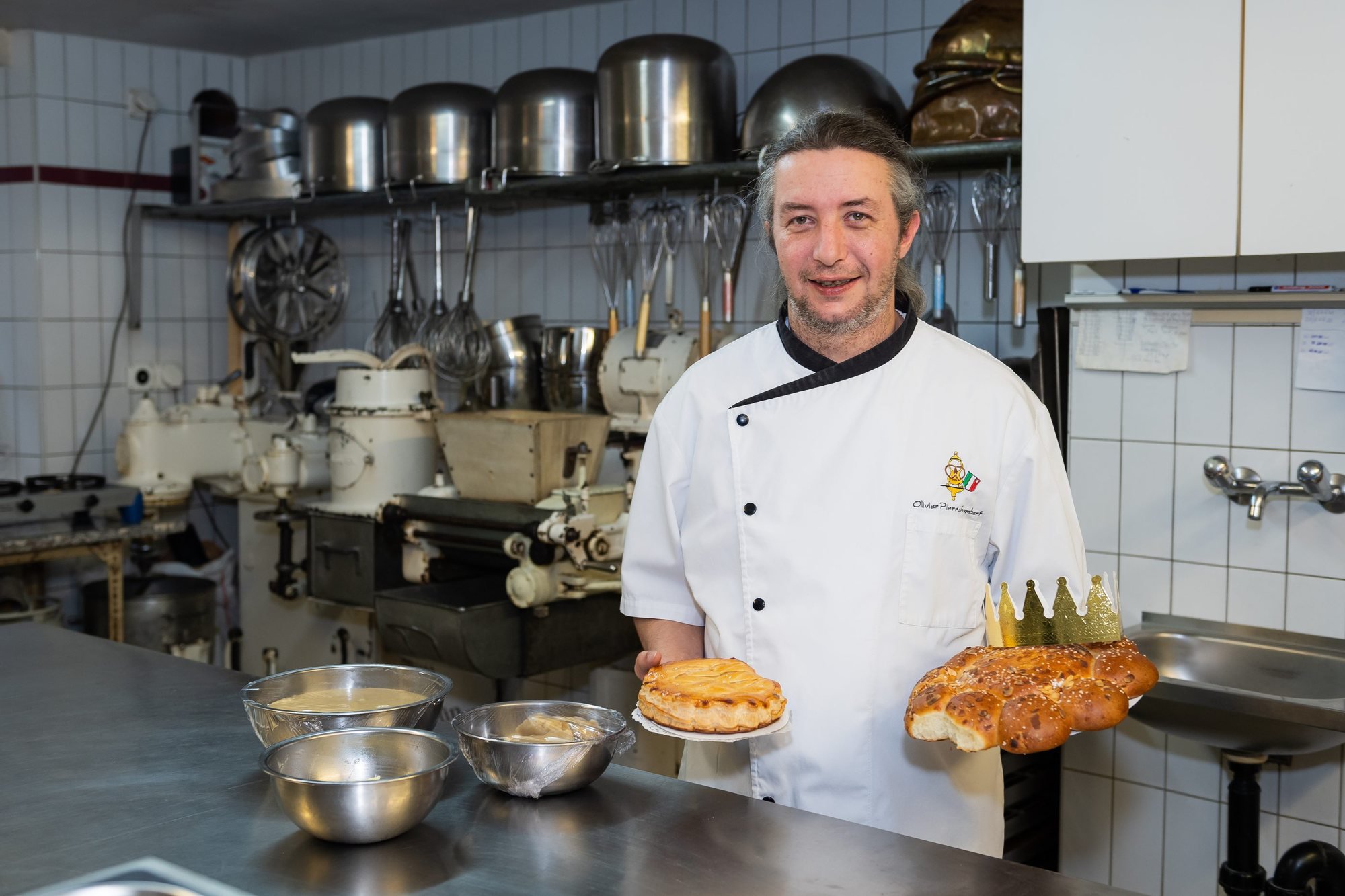 Olivier Pierrehumbert, avec sa galette et sa couronne des rois dans le laboratoire de sa boulangerie "Chez Tinet" à Saint-Aubin