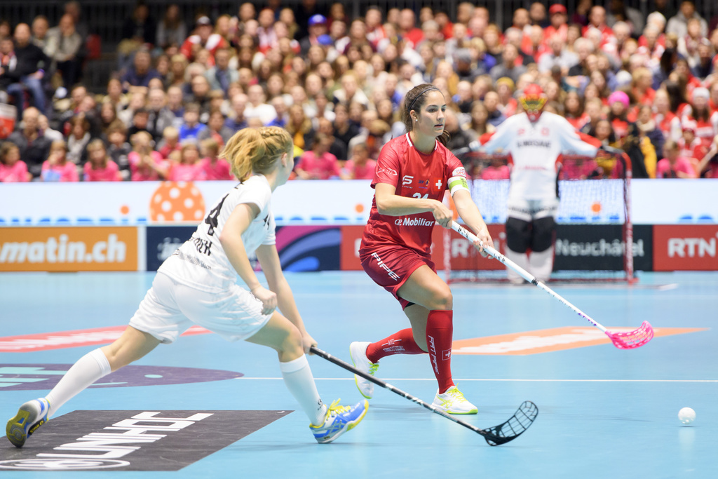 L'équipe de Suisse menée par la capitaine Flurina Marti (en rouge) n'a laissé aucune chance à Elena Bottrich (en blanc) et aux Allemandes pour leur premier match dans ce championnat du monde d'unihockey.