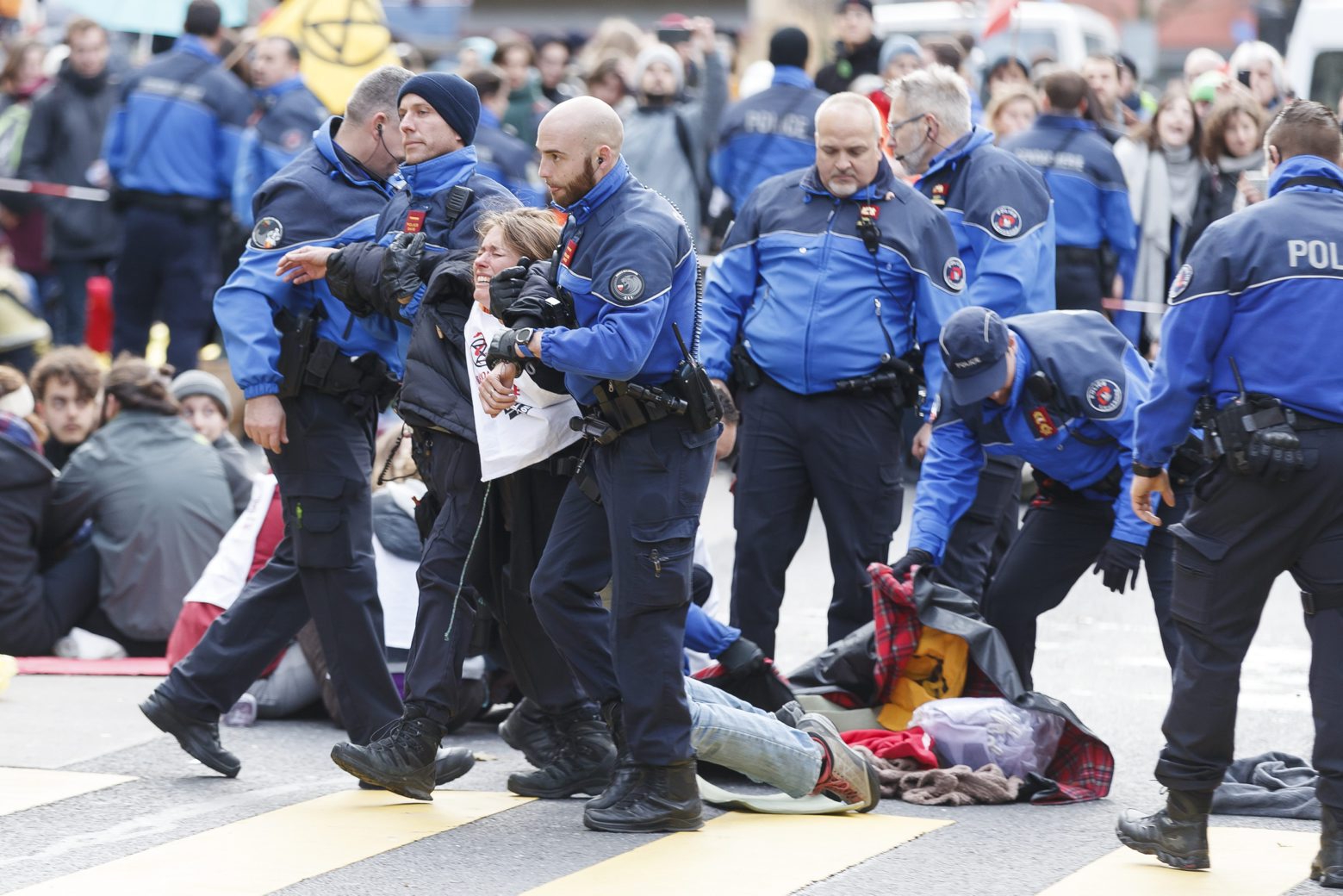 Des policiers evacuent les militants d'Extinction Rebellion qui bloquent les rues de Lausanne lors d'une action de bloquage d'Extinction Rebellion, XR, ce samedi, 14 decembre 2019  a Lausanne. Les manifestants demandent que les instances politiques prennent des mesures immediates au vu de l'urgence ecologique et climatique. (KEYSTONE/Cyril Zingaro) SUISSE ACTION EXTINCTION REBELLION