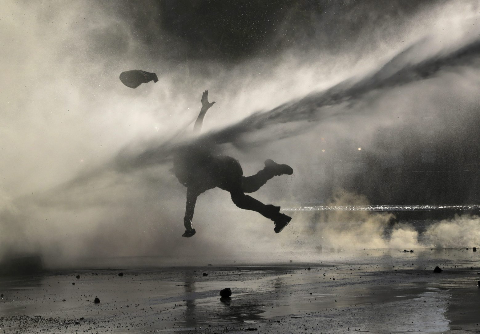 In this Dec. 9, 2019 photo, an anti-government demonstrator is sprayed by a police water cannon during a protest in Santiago, Chile. Student protests have become a nationwide call for socio-economic equality and better social services, so far forcing Chilean President Sebastian Pinera to increase benefits for the poor and disadvantaged and start a process of constitutional reform. (AP Photo/Fernando Llano) The Week That Was in Latin America Photo Gallery