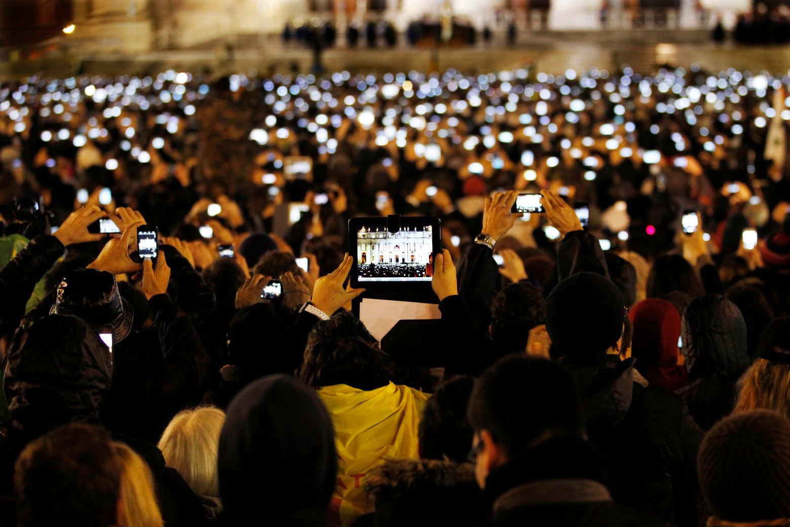 Visitors take photos of Pope Francis as he speaks from the central balcony of St. Peter's Basilica at the Vatican, Wednesday, March 13, 2013. Cardinal Jorge Bergoglio, who chose the name of Francis is the 266th pontiff of the Roman Catholic Church. (AP Photo/Michael Sohn) VATIKAN PAPST WAHL FRANZISKUS