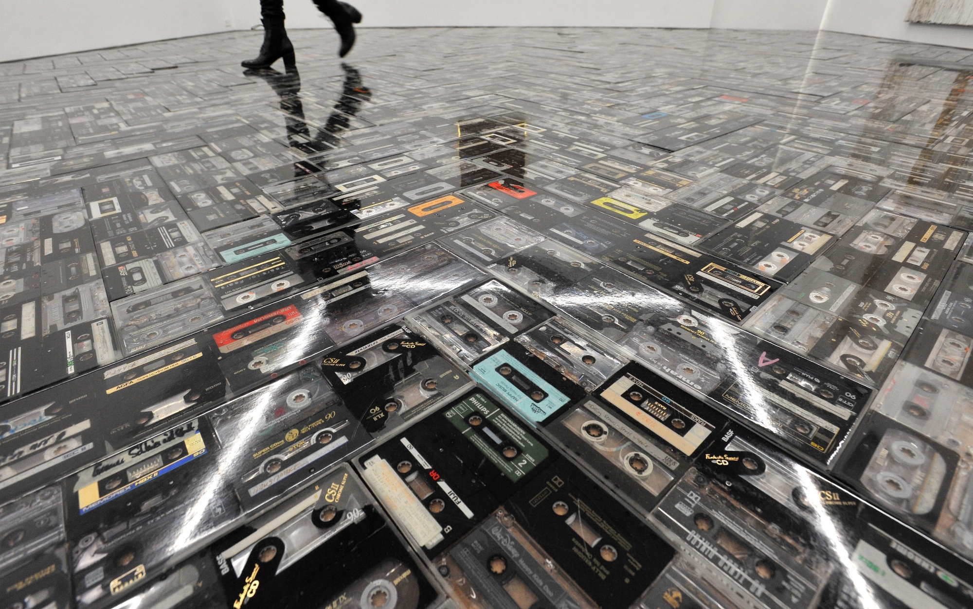 epa04027330 A view of a floor made up of cassette tapes as part of a show by German artist Gregor Hildebrandt called 'Die Geschichte laeuft ueber uns' (lit: The Story Runs About Us) at the Galerie Perrotin in New York, New York, USA, 17 January 2014. The show is made up of a series of pieces using a number of analog technologies.  EPA/JUSTIN LANE USA ARTS