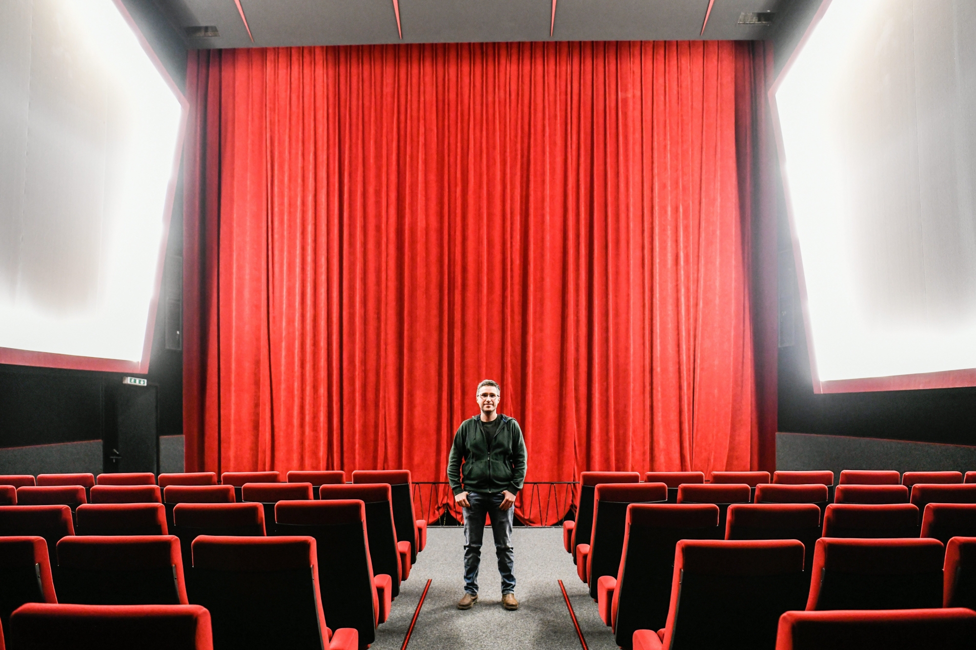 Bertrand Stoller, gérant du cinéma Colisée de Couvet, au milieu de la salle de 207 places.