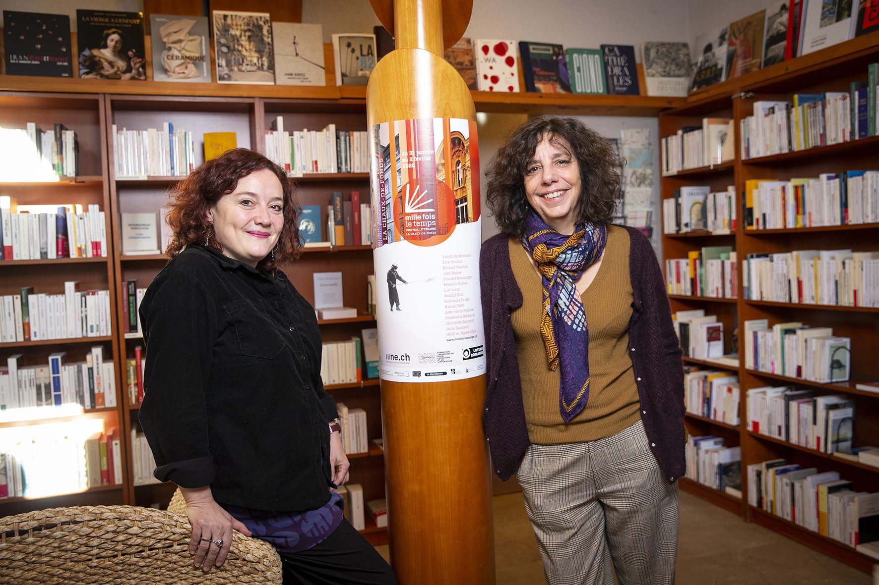 Anne Pellaton (à g.) et Marie-Joëlle Pedretti posent à la librairie La Méridienne, devant l’affiche de Mille fois le temps, leur festival littéraire.