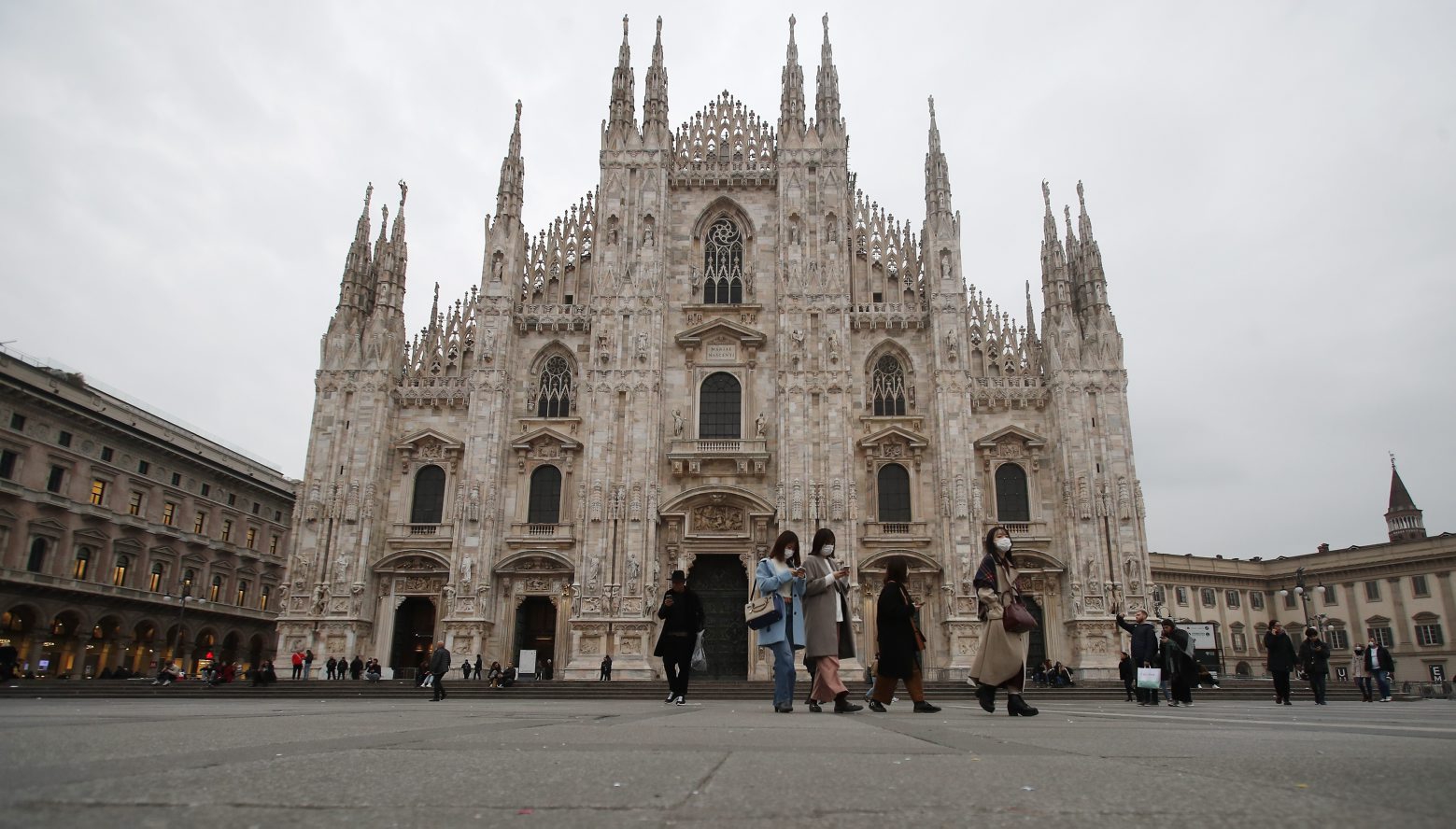 Women wearing face masks walks past the Duomo gothic cathedral in Milan, Italy, Tuesday, Feb. 25, 2020. Civil protection officials on Tuesday reported a large jump of cases in Italy, from 222 to 283. Seven people have died, all of them elderly people suffering other pathologies. (AP Photo/Antonio Calanni) Italy Virus Outbreak