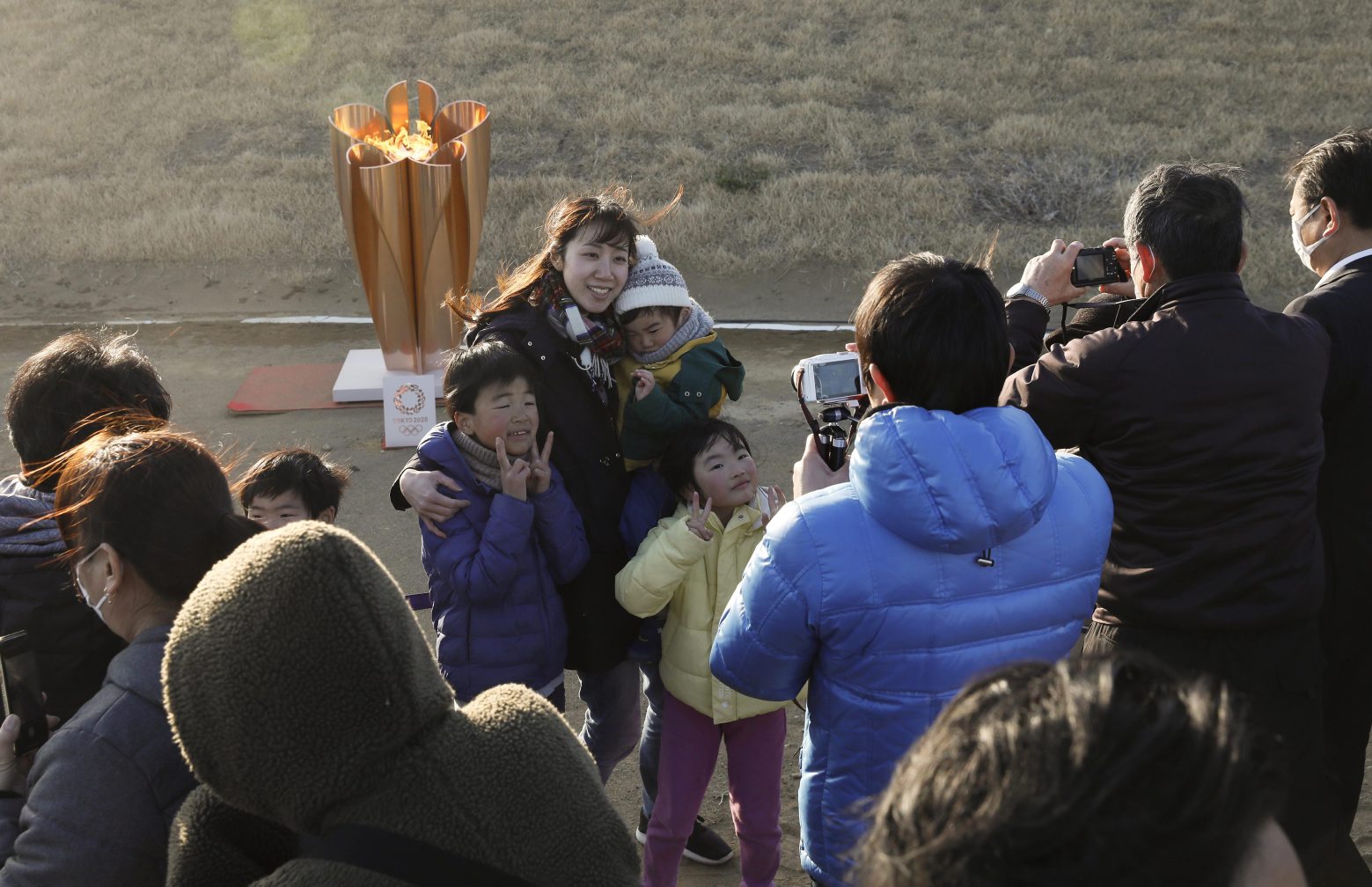 epa08308703 A family take a selfie with the Olympic flame on a cauldron displayed at Ishinomaki Minamihama Tsunami Recovery Memorial Park in Ishinomaki, Miyagi Prefecture, after the flame arrived in Higashimatsushima, northern Japan, 20 March 2020. Thousands of people in and out of the city make a long queue to see the flame displayed for about five hours. The Tokyo 2020 Olympic Flame arrival ceremony was scaled down over fears of coronavirus. Japanese Prime Minister Shinzo Abe is still considering holding the Tokyo Olympics as scheduled despite the current coronavirus pandemic.  EPA/KIMIMASA MAYAMA JAPAN PANDEMIC CORONAVIRUS COV?ID-19 OLYMPICS