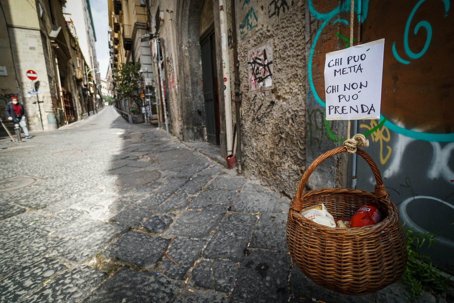 epaselect epa08331770 A solidarity basket with a note reading 'Who can may put, who cannot may take' is displayed in one of the deserted streets in the historic center of Naples, southern Italy, 30 March 2020. The mayor of Naples, Luigi de Magistris, said that the Municipality has a 'piggy bank' of around 10 million euros with which to deal with the emergency coronavirus by distributing grocery vouchers or basic necessities to those in need. Italy is under a complete lockdown in an attempt to stop the widespread of the SARS-CoV-2 coronavirus which causes the COVID-19 disease.  EPA/CESARE ABBATE epaselect ITALY PANDEMIC CORONAVIRUS COVID19