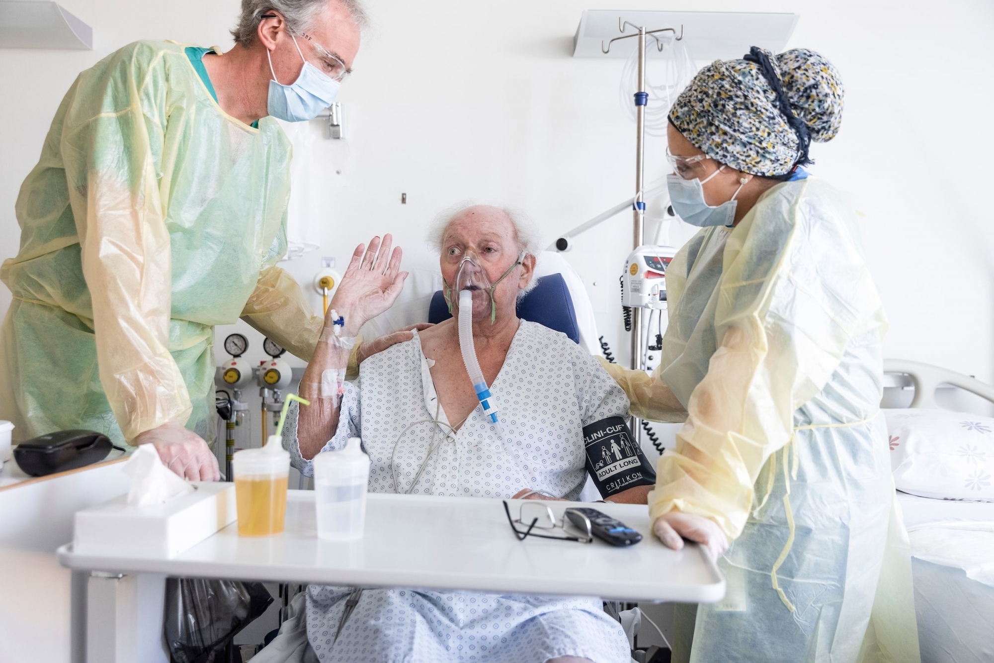 Un patient qui se remet du Covid-19 dans l'unité de ventilation non invasive. A sa droite, une infirmière du service et à sa gauche, le Pr Jean-Marc Fellrath.