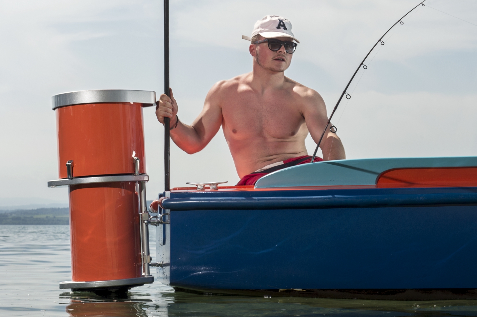 Un pêcheur amateur pose sur un bateau à côté du moteur Outboard "Navigaflex", sur le lac de Neuchâtel